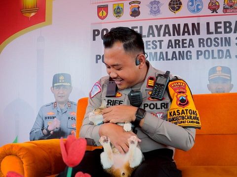Kasat Lantas Polres Pemalang AKP Arief Wiranto mengamankan kucing milik pemudik di Pos Pelayanan Operasi Ketupat Candi 2025 Rest Area 319B Pemalang, Selasa (8/4/2025).