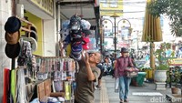 Pedagang kaki lima menata topi dagangan di Jalan HZ Mustofa.