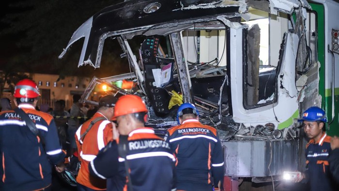 Sejumlah petugas mengevakuasi truk bermuatan kayu yang tertabrak kereta api commuter line Jenggala di Desa Tenggulunan, Kebomas, Gresik, Jawa Timur, Selasa (8/4/2025). Kereta api commuter line Jenggala relasi Gresik-Sidoarjo tersebut bertabrakan dengan truk bermuatan kayu di jalur perlintasan langsung (JPL) KM 7+600 antara Stasiun Indro-Kandangan Gresik dan mengakibatkan satu orang asisten masinis meninggal dunia dan satu orang masinis mengalami luka berat. ANTARA FOTO/Rizal Hanafi/Spt.