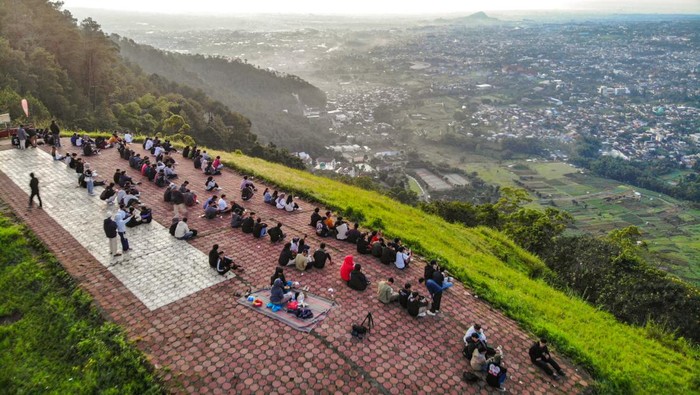 Kunjungan wisatawan di Kota Wisata Batu Foto udara sejumlah pengunjung menikmati suasana matahari terbit di kawasan wisata Paralayang, Batu, Jawa Timur, Rabu (9/4/2025). Menurut Dinas Pariwisata setempat Kawasan yang menjadi destinasi wisata unggulan Jawa Timur itu menjadi tempat yang paling banyak dikunjungi pada periode libur Lebaran, yakni sebanyak 597.737 kunjungan wisatawan mulai tanggal 22 Maret hingga 7 April 2025 dan diperkirakan akan terus naik. ANTARA FOTO/Muhammad Mada/YU