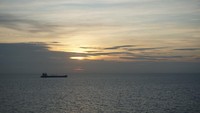 Dari kejauhan, sang Surya makin lama makin tenggelam diiringi dengan lalu lalang kapal yang melintas di Selat Melaka. (Wahyu/detikTravel)