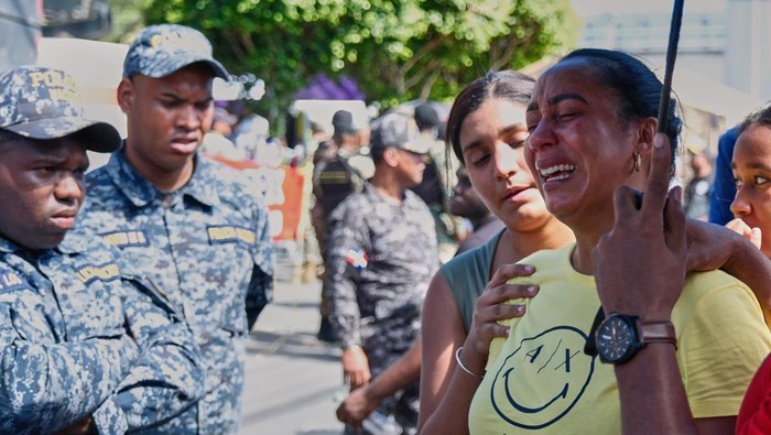 Relatives of missing people embrace while waiting at the National Institute of Forensic Pathology after the roof collapsed at Jet Set nightclub during a merengue concert in Santo Domingo, Dominican Republic, Tuesday, April 8, 2025. (AP Photo/Ricardo Hernandez)