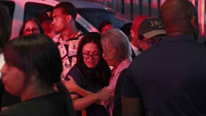 Tangis Pilu Keluarga Korban Runtuhnya Atap Kelab Malam di Dominika Relatives of missing people embrace while waiting at the National Institute of Forensic Pathology after the roof collapsed at Jet Set nightclub during a merengue concert in Santo Domingo, Dominican Republic, Tuesday, April 8, 2025. (AP Photo/Ricardo Hernandez)