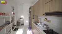 Area dapur kotornya ini dilengkapi dengan rak, kulkas, dan wastafel. Meskipun dapur kotor, tetapi konsepnya tak jauh dari gaya Japandi. Foto: YouTube MAIA ALELDUL TV
