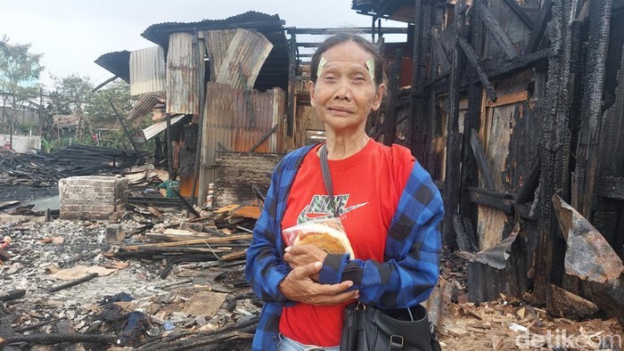 Eti menunjukkan sisa rumahnya yang terbakar.