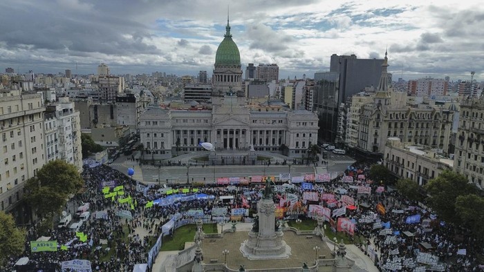 A demonstrator waves a  flag during a weekly protest by retirees against President Javier Milei's austerity measures in Buenos Aires, Argentina, Wednesday, April 9, 2025. (AP Photo/Rodrigo Abd)