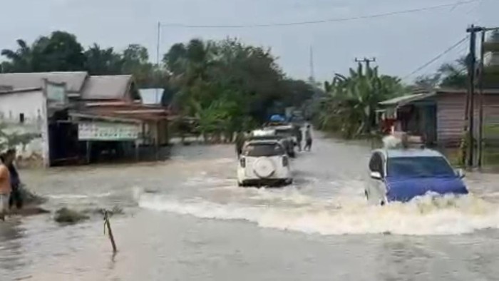 Petugas dan masyarakat bersiaga di lokasi banjir.