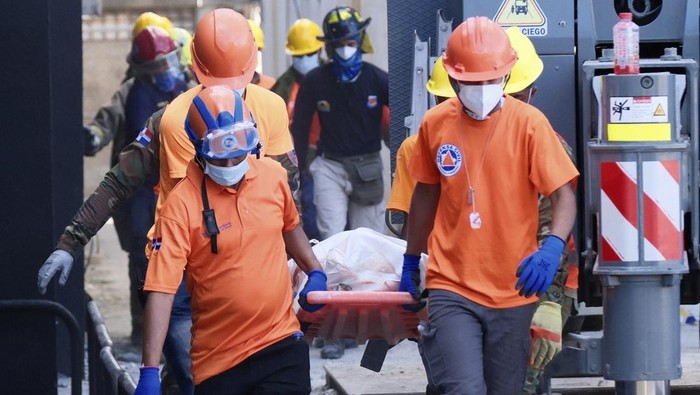 Rescue workers carry the recovered body of a victim who died when the roof collapsed two nights prior at the Jet Set nightclub during a merengue concert, in Santo Domingo, Dominican Republic, Wednesday, April 9, 2025. (AP Photo/Ricardo Hernandez)