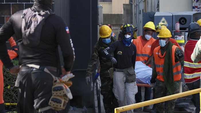 Rescue workers carry the recovered body of a victim who died when the roof collapsed two nights prior at the Jet Set nightclub during a merengue concert, in Santo Domingo, Dominican Republic, Wednesday, April 9, 2025. (AP Photo/Ricardo Hernandez)