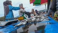 Pedagang menimbang ikan saat transaksi dengan pembeli di TPI Higienis Sodoha, Kendari, Sulawesi Tenggara, Kamis (10/4/2025).