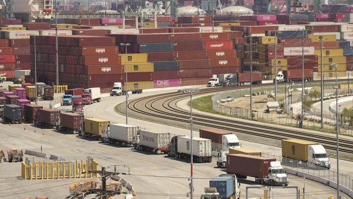 Aktivitas di Pelabuhan Kargo Terbesar AS di Tengah Kebijakan Tarif Impor Trump Trucks wait to load shipping containers at the Port of Los Angeles, Wednesday, April 9, 2025, in Los Angeles. (AP Photo/Damian Dovarganes)