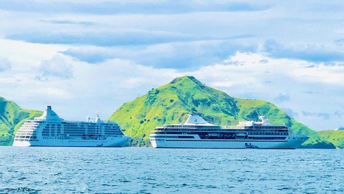 Dua kapal pesiar bersandar bersamaan di perairan Pulau Komodo, Taman Nasional Komodo, Manggarai Barat, NTT, Kamis (10/4/2025).