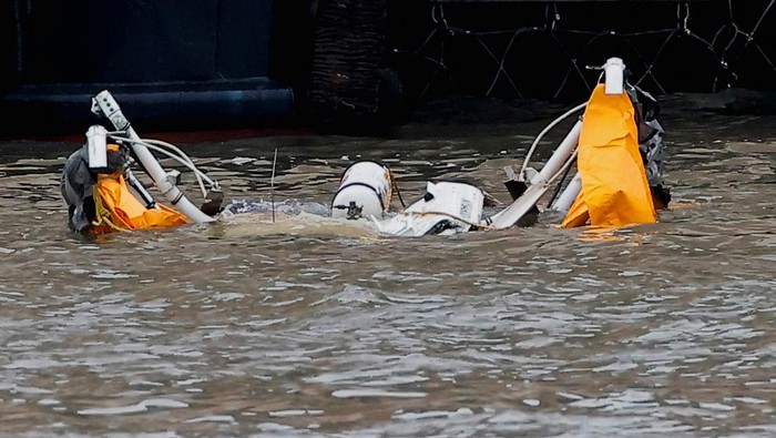 Helikopter Masuk Sungai di New York, Seluruh Penumpang Tewas People look on from a building as emergency personnel work at the scene of a helicopter crash on the Hudson River near lower Manhattan in New York, as seen from Newport, New Jersey U.S., April 10, 2025. REUTERS/Eduardo Munoz