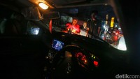 Warga gotong-royong mengangkat mobil berwarna hitam itu, sementara sebagian lainnya mengurai arus lalu lintas.