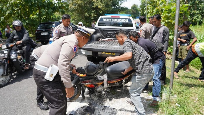 Petugas mengevakuasi motor yang terlibat kecelakaan di Jalan Jogja-Wonosari, Patuk, Gunungkidul, Jumat (11/4/2025).