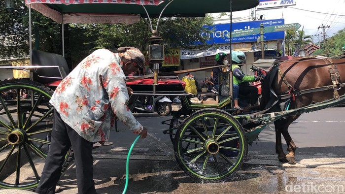 Potret kusir andong membersihkan tempat parkir andong di kawasan Malioboro, Jogja, Jumat (11/4/2025).