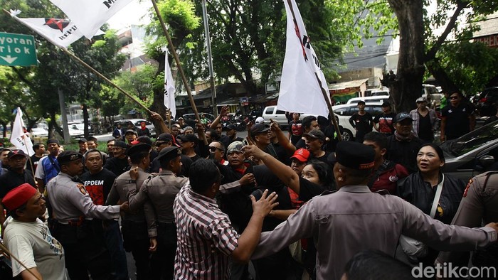 Massa pendukung pembebasan Hasto yang mengenakan baju hitam terlibat bentrok dengan massa yang meminta Hasto dihukum di depan Pengadilan Tipikor, Jakarta, Jumat (11/5/2025).
