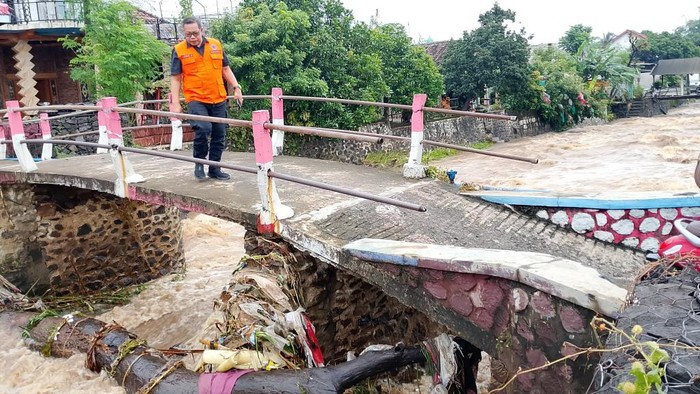 Sampah batang pohon besar yang menyumbat jembatan Purwoasri, Pasuruan hingga menyebabkan banjir di Jalan Raya Malang-Surabaya.