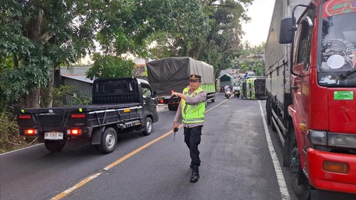 Satlantas Polres Tabanan mengatur arus lalu lintas di lokasi truk memuat air minum kemasan terguling di Jalan Denpasar-Gilimanuk, Banjar Dinas Kutuh, Desa Lalanglinggah, Kecamatan Selemadeg Barat, Jumat (11/4/2025). (Dok. Polres Tabanan)