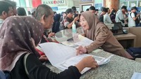 Petugas memberikan informasi kepada warga yang mengikuti program pemutihan pajak kendaraan.