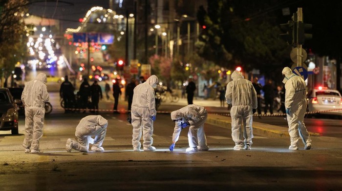 Customers and staff of a nearby hotel stand behind. police cordon, following a bomb blast outside the Hellenic Train offices, in Athens, Greece, April 11, 2025. REUTERS/Stelios Misinas