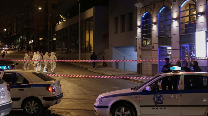 Customers and staff of a nearby hotel stand behind. police cordon, following a bomb blast outside the Hellenic Train offices, in Athens, Greece, April 11, 2025. REUTERS/Stelios Misinas