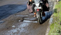 Pengguna jalan terlihat menghindari jalan berlubang di Jalan Raya Bojonegoro-Babat.