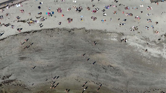 People stand on top of the Blackrock Diving Tower as they enjoy hot weather on the beach, in Galway, Ireland April 10, 2025. REUTERS/Clodagh Kilcoyne