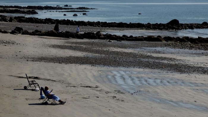 People stand on top of the Blackrock Diving Tower as they enjoy hot weather on the beach, in Galway, Ireland April 10, 2025. REUTERS/Clodagh Kilcoyne