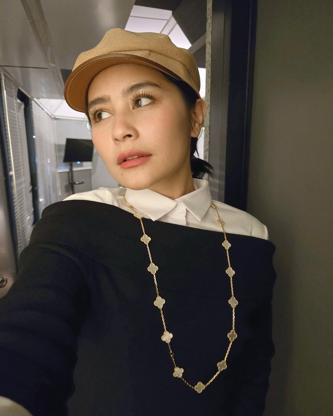 Tidak ketinggalan topi baret berwarna nude yang semakin menyempurnakan gayanya. Riasan wajah yang simple menjaga gayanya tetap elegan. (Foto: Instagram/@prillylatuconsina96)