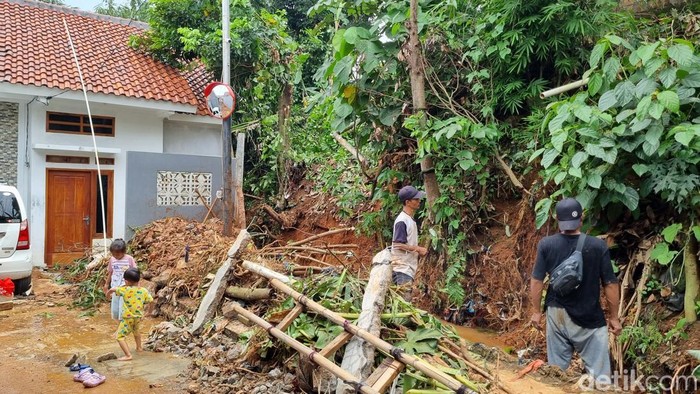 Tembok panjang pembatas antara tebing dan parit ambruk usai hujan deras mengakibatkan sejumlah rumah di Cipayung, Kota Depok, kebanjiran. (Taufiq S/detikcom)