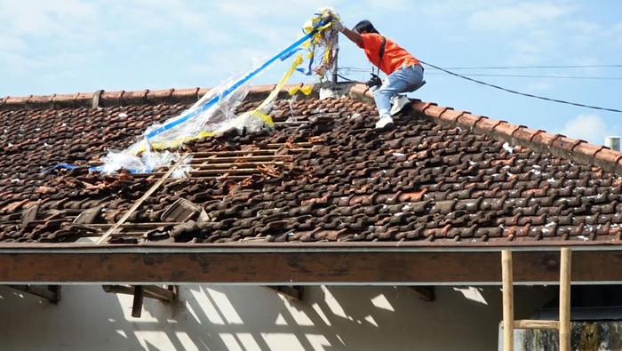 Petugas mengidentifiksi kerusakan rumah warga terdampak ledakan balon udara berpetasan di Desa Suruhan Lor, Tulungagung, Jawa Timur, Minggu (13/4/2025). Polisi mencari sebanyak 15 remaja, sebagian di antaranya anak di bawah umur, yang diidentifikasi sebagai pelaku penerbangan balon udara berpetasan yang menyebabkan sebuah rumah warga rusak berat. ANTARA FOTO/Destyan Sujarwoko/rwa.