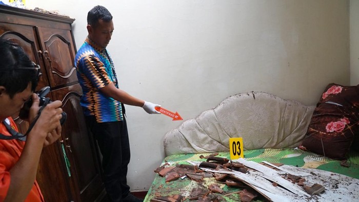 Petugas mengidentifiksi kerusakan rumah warga terdampak ledakan balon udara berpetasan di Desa Suruhan Lor, Tulungagung, Jawa Timur, Minggu (13/4/2025). Polisi mencari sebanyak 15 remaja, sebagian di antaranya anak di bawah umur, yang diidentifikasi sebagai pelaku penerbangan balon udara berpetasan yang menyebabkan sebuah rumah warga rusak berat. ANTARA FOTO/Destyan Sujarwoko/rwa.