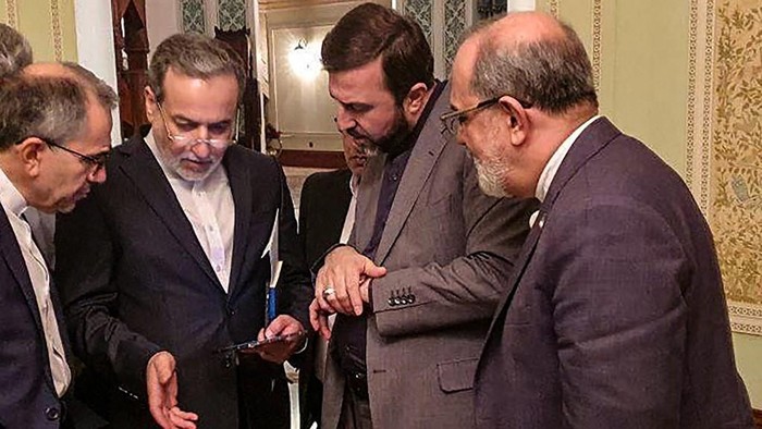 Foto selebaran yang disediakan oleh Khabar Online pada 12 April 2025 ini menunjukkan Menteri Luar Negeri Iran, Abbas Araghchi (kedua dari kiri), berbicara dengan anggota delegasi Iran setelah sebuah pertemuan di Muscat.