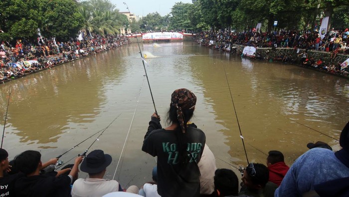 Warga mengikuti mancing massal di Situ Gedung Kesenian, Cibinong, Kabupaten Bogor, Jawa Barat, Minggu (13/4/2025). Mancing massal yang diselenggarakan Pemerintah Kabupaten Bogor itu sebagai ajang halalbihalal warga, dan diikuti oleh ribuan peserta dengan total ikan mas (Cyprinus carpio) yang disediakan sebanyak satu ton.