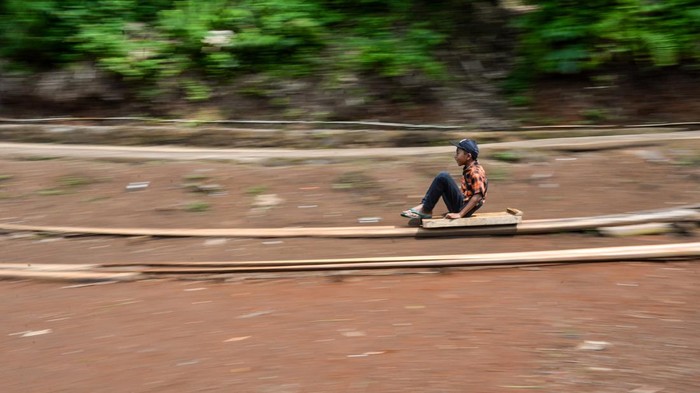 Anak-anak bermain permainan tradisional lori dari pohon aren di Kampung Ciherang, Desa Cihaurkuning, Malangbong, Kabupaten Garut, Jawa Barat, Minggu (13/4/2025). Permainan tradisional lori yang terbuat dari pohon aren sepanjang 120 meter hasil dari swadaya masyarakat tersebut dibuat kembali untuk melestarikan permainan tradisional dari Malangbong, Kabupaten Garut serta ditujukan sebagai salah satu upaya menghindari kecanduan gawai pada anak.