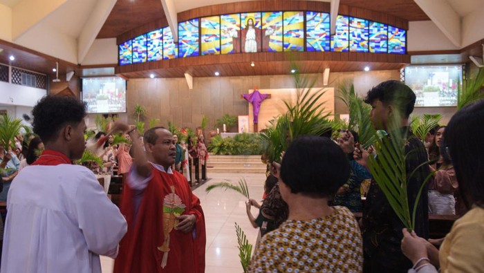 Sejumlah umat Katolik mengikuti misa perayaan Minggu Palim di Gereja Katolik Santo Petrus Argapura, Kota Jayapura, Papua, Minggu  (13/4/2025). Umat Katolik di seluruh dunia mulai memasuki masa pekan suci yang diawali dengan perayaan Minggu Palma untuk mengenang Yesus masuk ke Kota Yerusalem dan dielu-elukan oleh orang banyak dengan daun palma di tangan. ANTARA FOTO/Gusti Tanati.