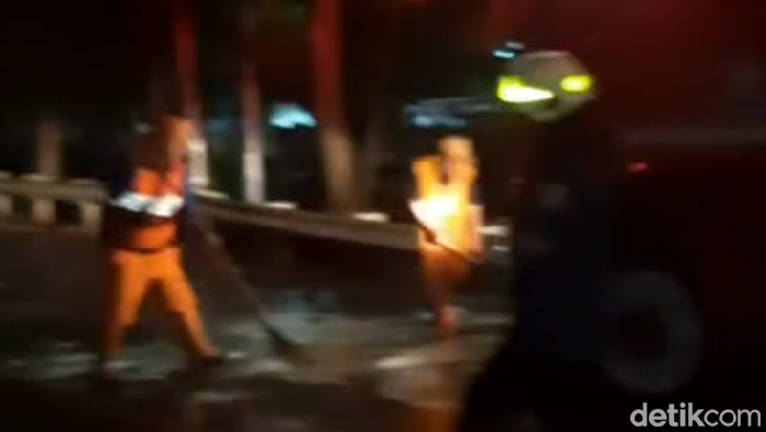 Damkar Jakarta Utara membersihkan tumpahan solar di Jalan Danau Sunter, Jakut.