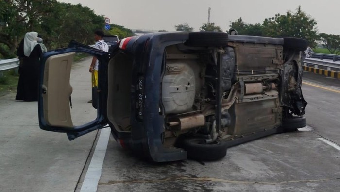 Grand Livina yang memuat WNA terguling di Tol Jomo. Tiga orang terluka termasuk sopir yang diduga mengantuk.