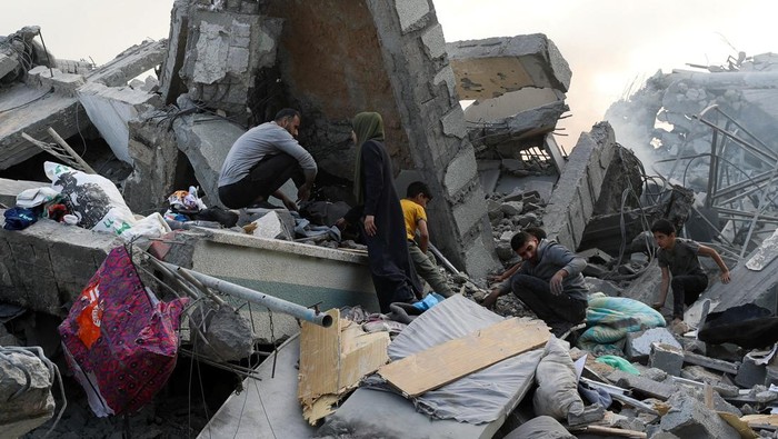 Palestinians inspect the damage at the Dar Al-Arqam school, where displaced people shelter, after it was hit by an Israeli strike on Thursday, in Gaza City, April 4, 2025. REUTERS/Mahmoud Issa     TPX IMAGES OF THE DAY