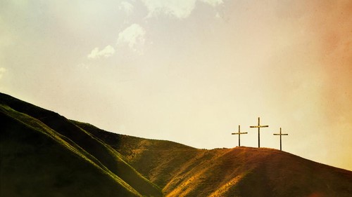 A depiction of the crucifixion of Jesus Christ, three crosses on a hill. Imagery intended to represent the crucifixion and resurrection of Jesus Christ celebrated on Easter sunday. Horizontal image with copy space.