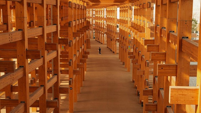 A man walks under the Grand Ring, the largest wooden architectural structure according to Guinness World Records, during a media tour before the official opening of Expo 2025 in Osaka, Japan March 26, 2025. REUTERS/Tom Bateman