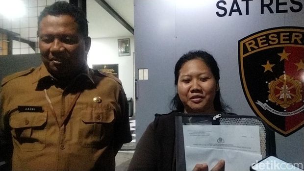 Nila, karyawan yang mengaku ijazahnya ditahan menunjukkan laporan polisi ke Polrestabes Surabaya.