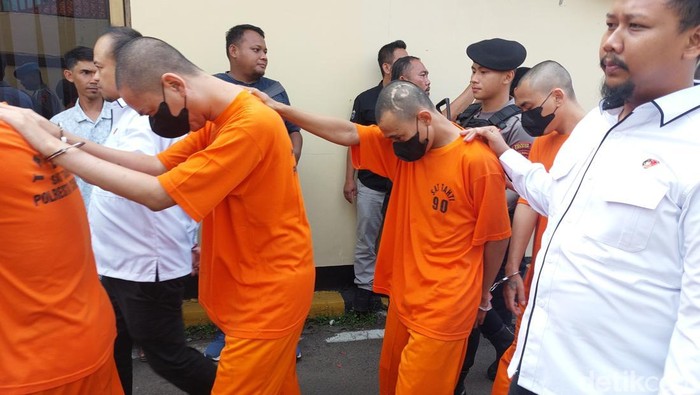 Polisi saat menggiring tersangka penyalahgunaan narkotika dan sediaan farmasi tanpa izin