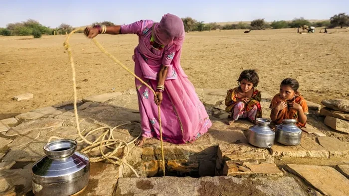 Seorang wanita dan kedua anaknya mengambil air dari sumur di Gurun Thar, yang juga dikenal sebagai Gurun Besar India.