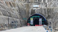 Dari sisi kiri, terlihat detail konstruksi dengan metode NATM (New Austrian Tunneling Method). Metode ini memungkinkan penggalian, pengerasan, dan pelapisan dilakukan secara bersamaan sehingga mempercepat proses tanpa mengorbankan kualitas dan keselamatan.