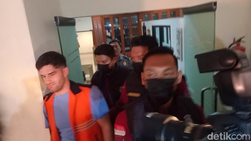 WN Amerika Serikat, Mcmahon Mithcell, digiring petugas saat konferensi pers di kantor Imigrasi Denpasar, Senin (14/4/2025). (Foto: Aryo Mahendro/detikBali)