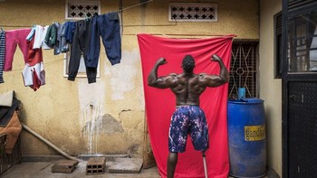 Kategori Africa - Single. Karya Marijn Fidder dari Belanda. Pada 2020, binaragawan Tamale Safalu kehilangan kaki akibat kecelakaan motor. Meski menghadapi tantangan fisik dan emosional, ia bangkit melalui rehabilitasi dan menjadi atlet penyandang disabilitas pertama di Uganda yang bersaing dengan atlet nondisabilitas dalam kompetisi binaraga. Kini, Safalu bercita-cita menjadi juara disabilitas pertama di Arnold Classic. Baginya, berkompetisi bukan hanya soal prestasi pribadi, tetapi juga mengubah persepsi dan menginspirasi orang lain: “Saya ingin mendorong penyandang disabilitas mengenali bakat mereka dan tidak menyerah.” Ketangguhannya menantang stereotip dan menginspirasi banyak orang. Foto: World Press Photo