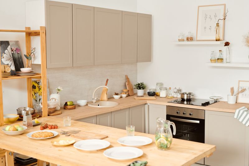 Large equipped kitchen with served table and kitchenware inside contemporary flat or house
