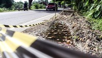 Sebuah mobil melintas di dekat bahu Jalan Raya Nasional Aceh-Medan, Sumatera Utara yang rusak di kawasan Blang Panyang, Lhokseumawe, Aceh, Selasa (15/4/2025).